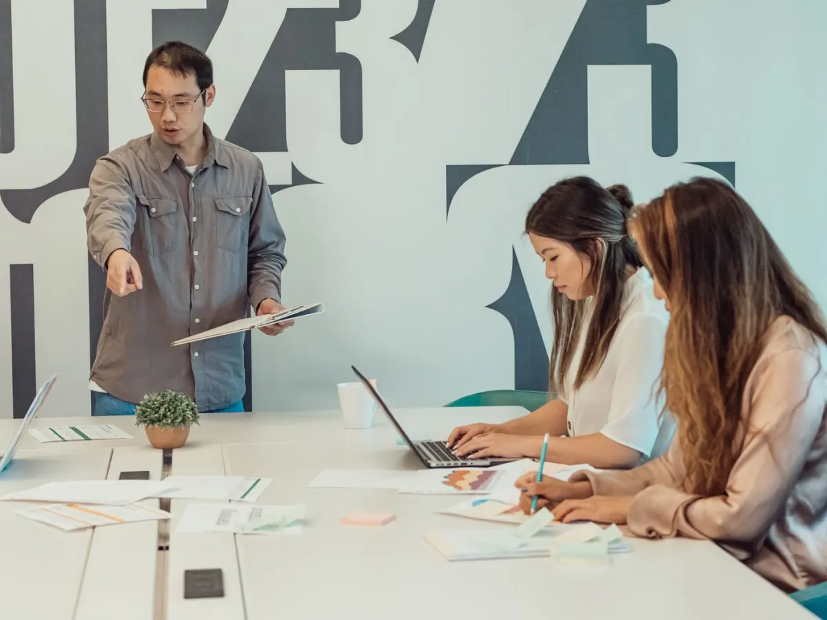 Business colleagues reviewing work together around an office table