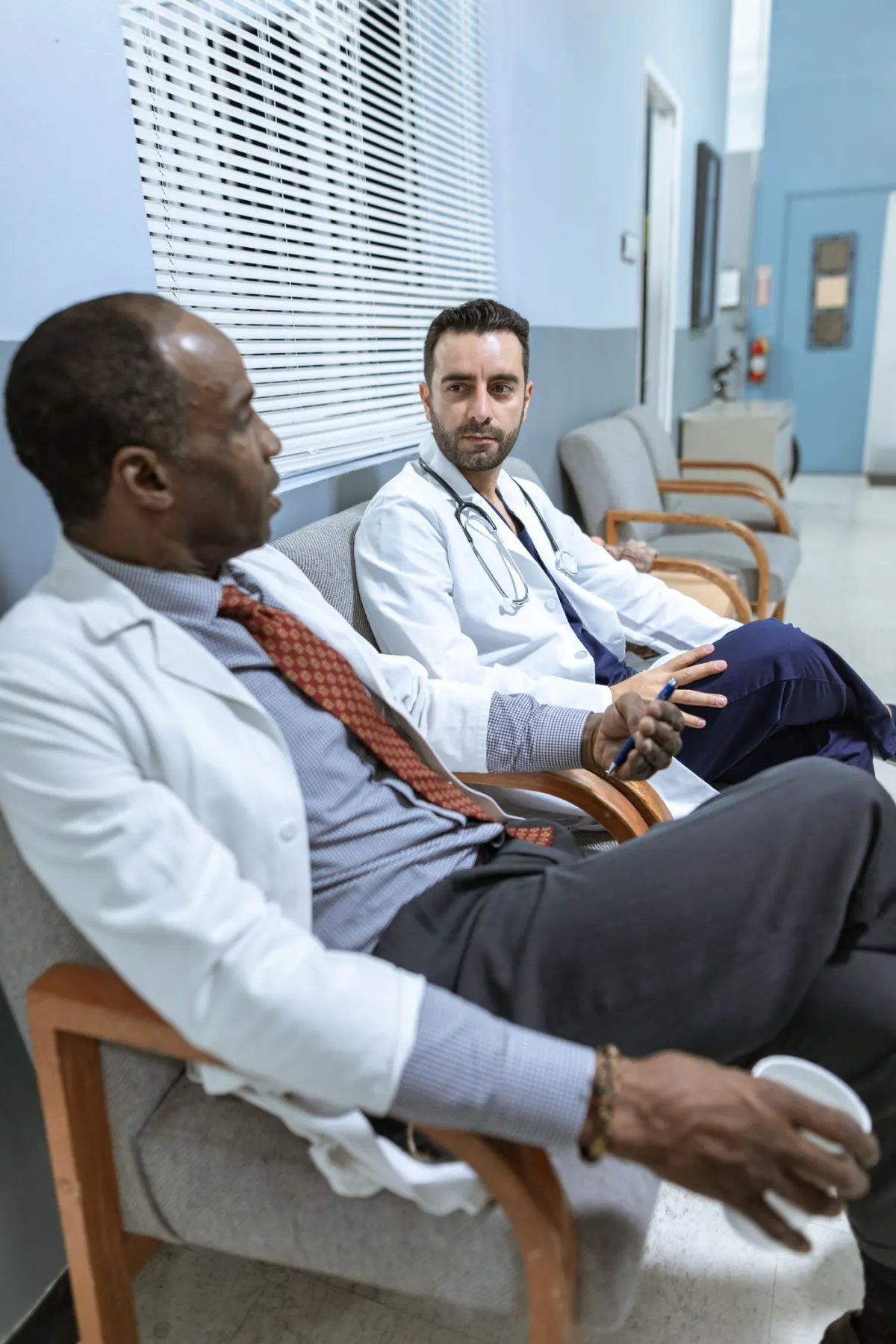 Two doctors seated together discussing information in a clinical setting