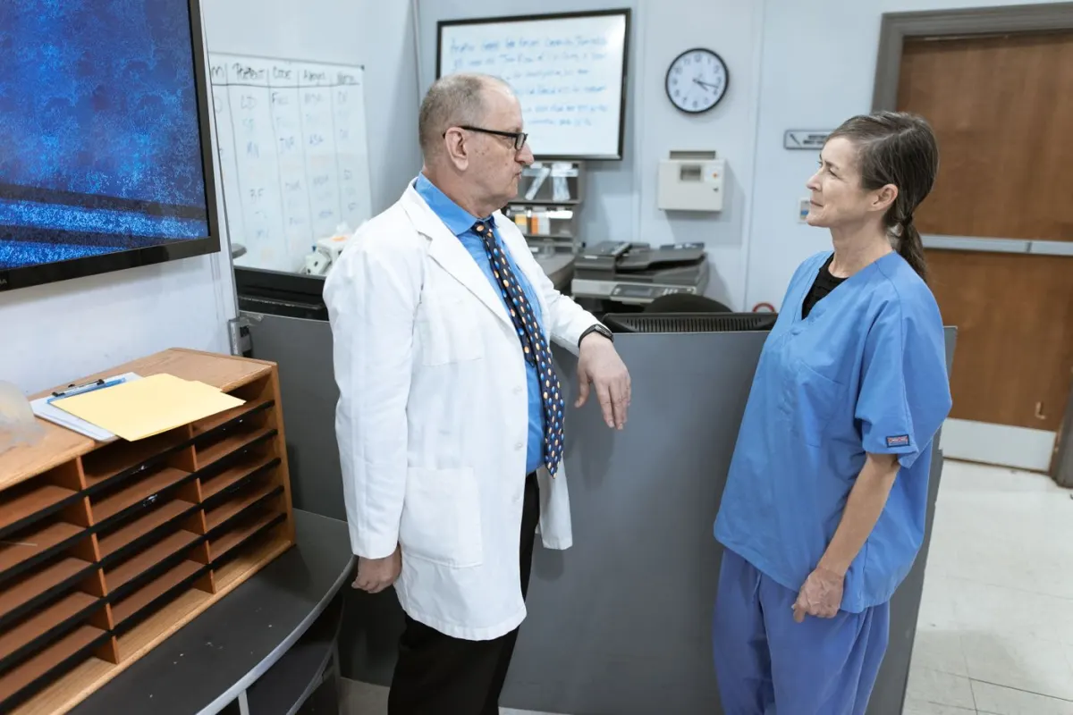 Medical practitioners discussing information together in a hospital corridor