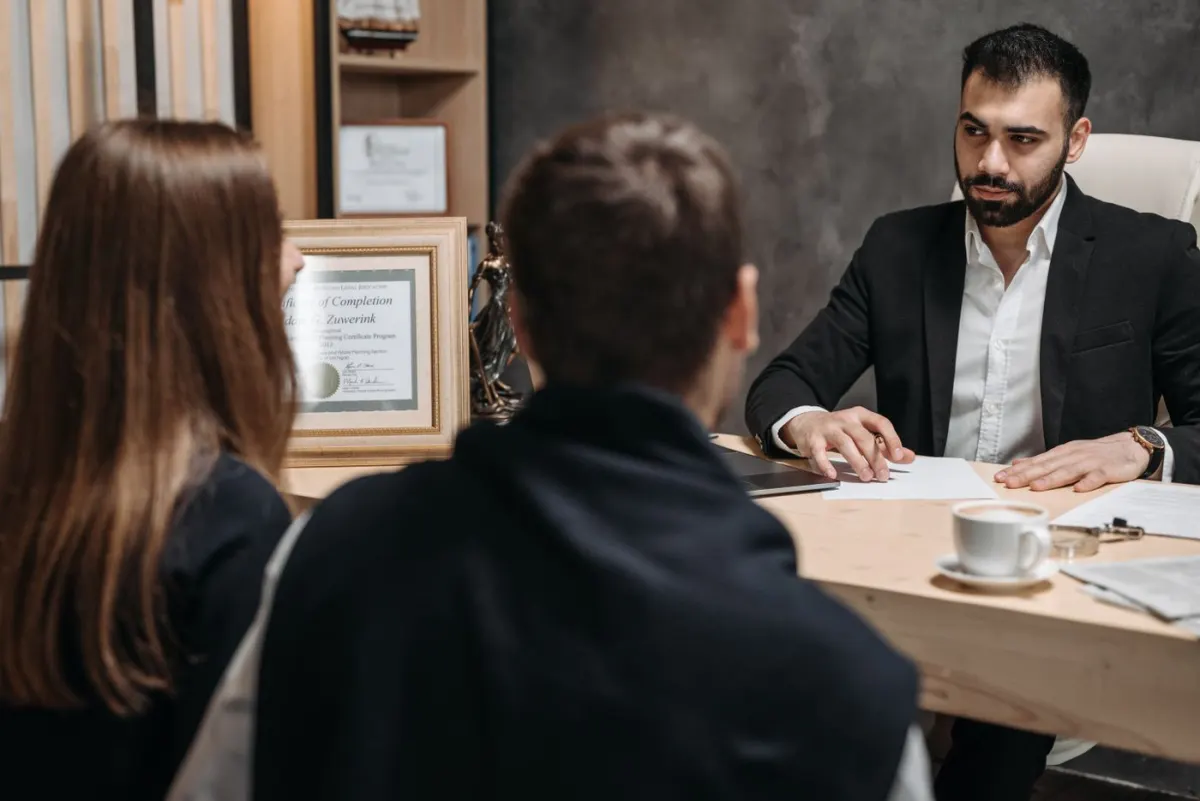 Lawyer meeting clients at a desk to discuss documents