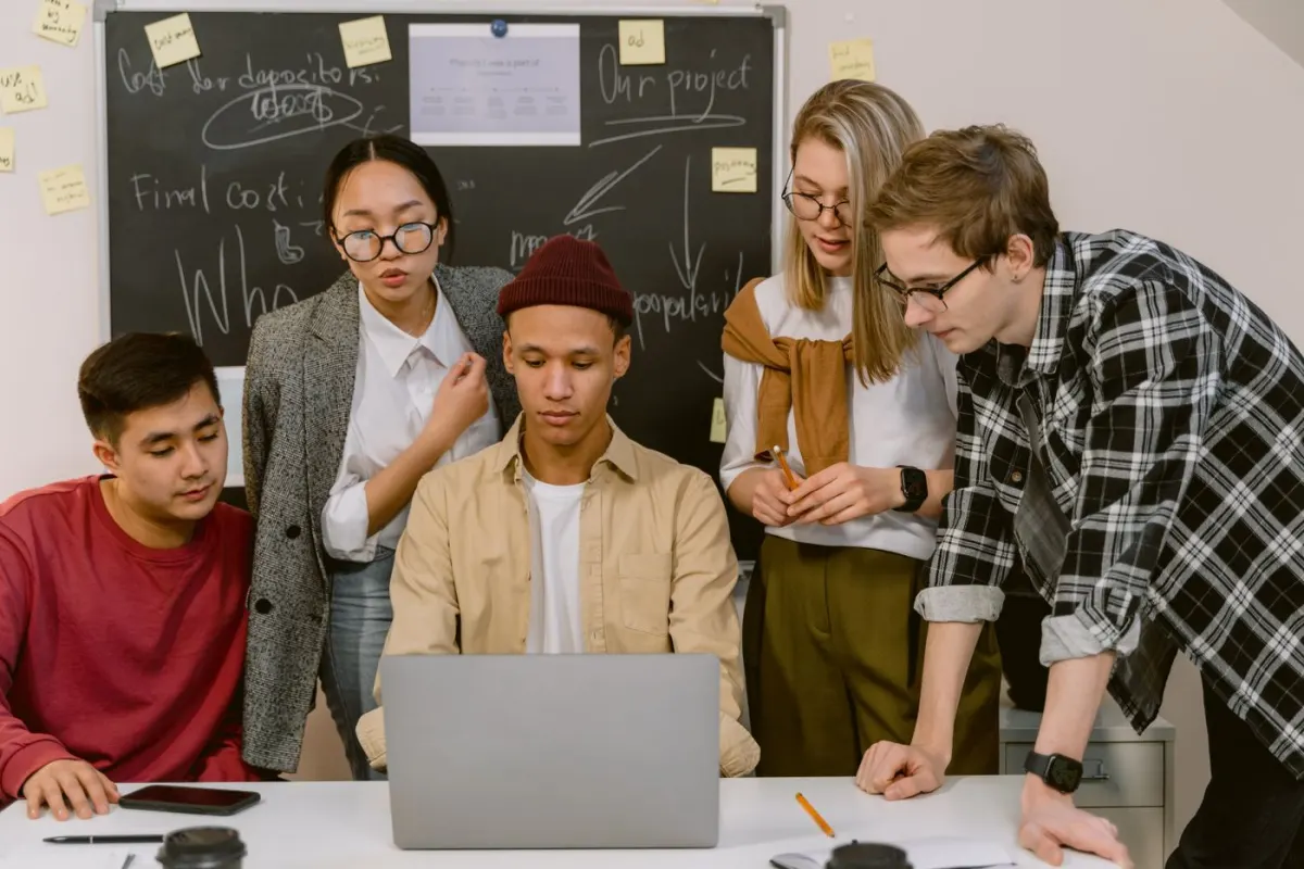 Startup colleagues discussing their work around a table with a laptop